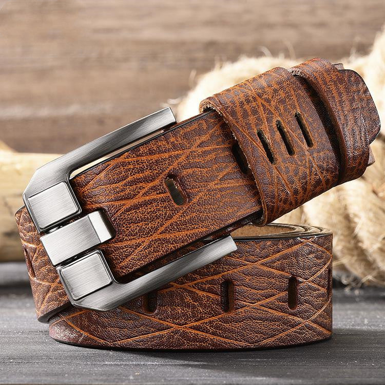Brown leather belt with silver buckle on a wooden surface