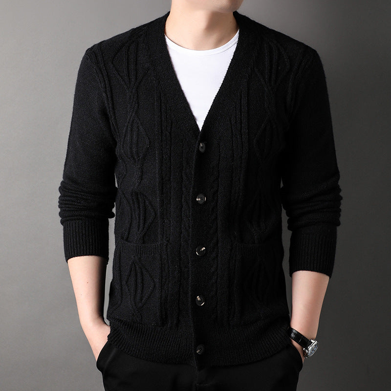 Black knitted cardigan worn by a person on a gray background