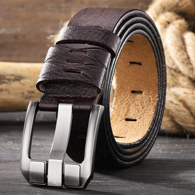 Brown leather belt with silver buckle on a wooden surface