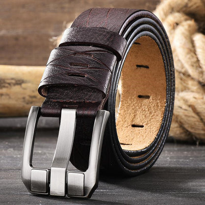 Brown leather belt with silver buckle on a wooden surface