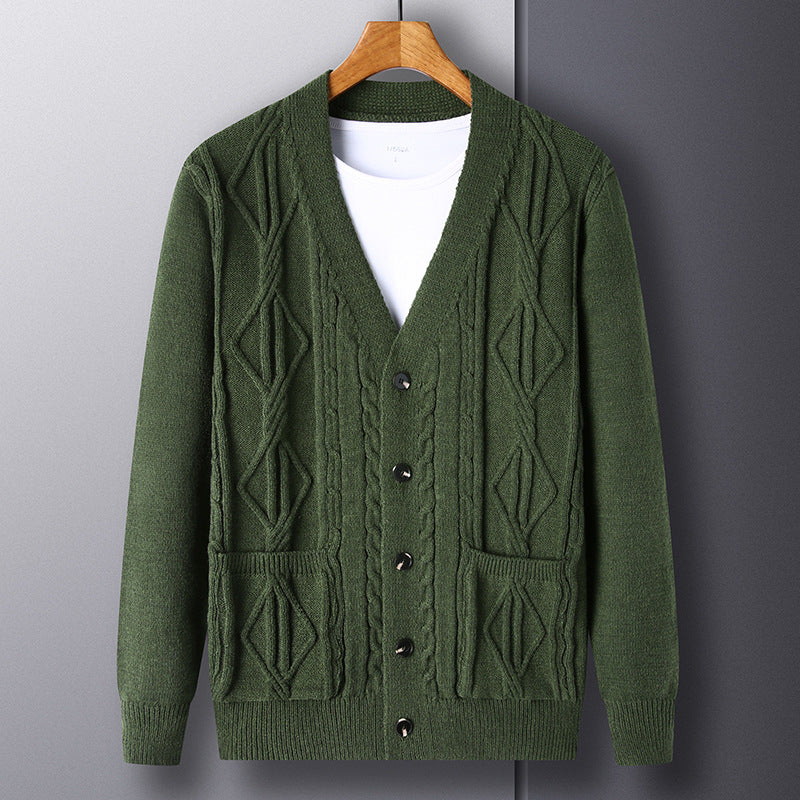 Green cardigan on a wooden hanger against a gray background