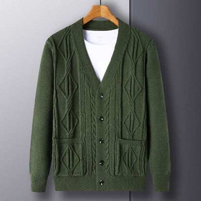 Green cardigan on a wooden hanger against a gray background