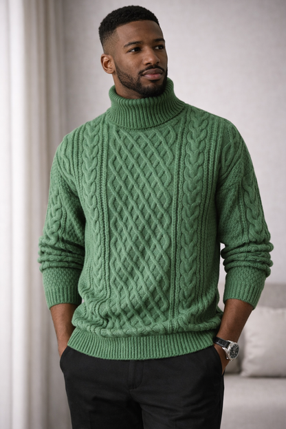 Man wearing a green cable knit sweater in a neutral setting