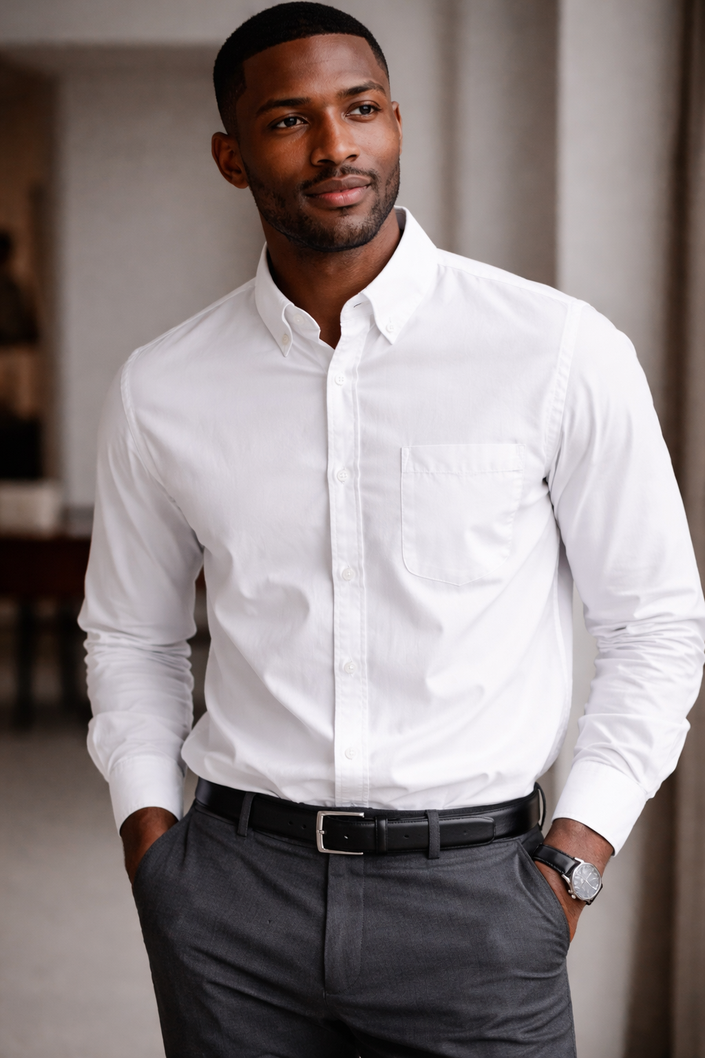 Man wearing a white dress shirt and dark pants indoors