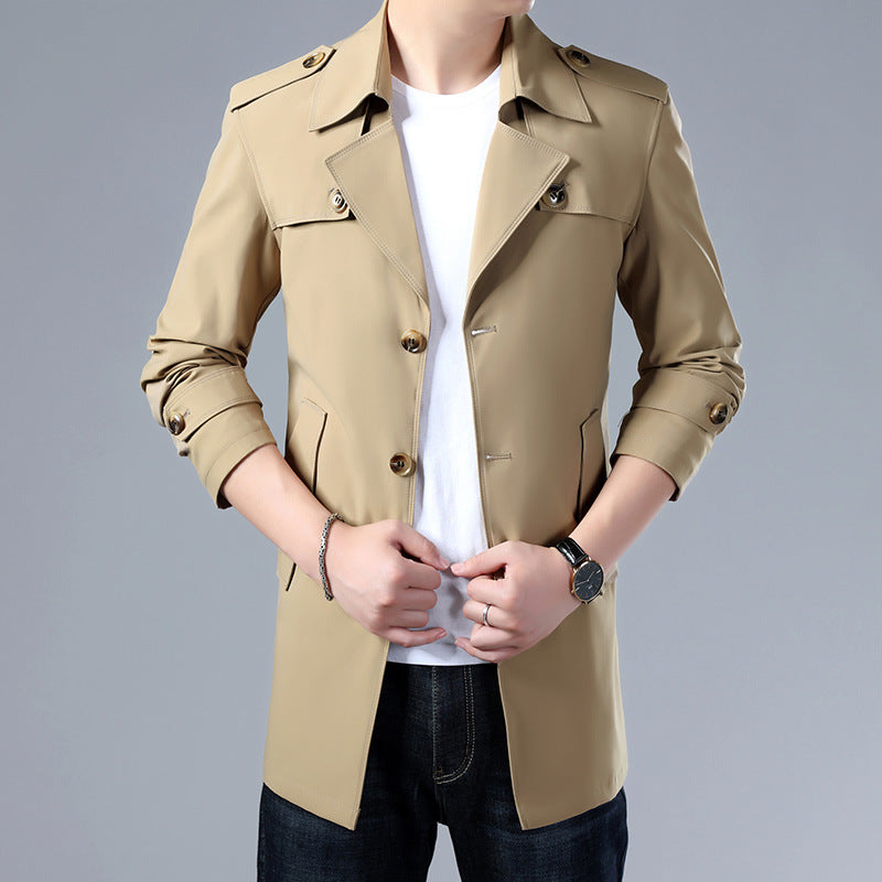 Beige trench coat worn by a person on a gray background