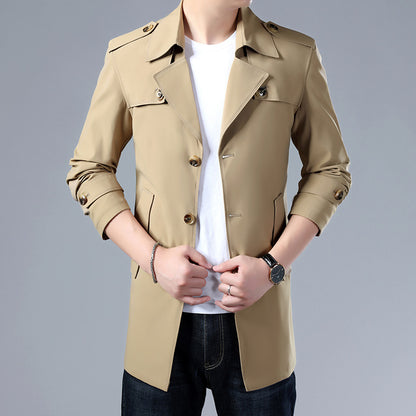 Beige trench coat worn by a person on a gray background