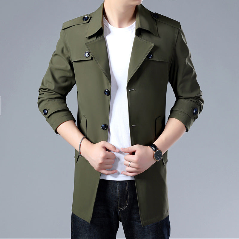 Green trench coat worn by a person on a gray background