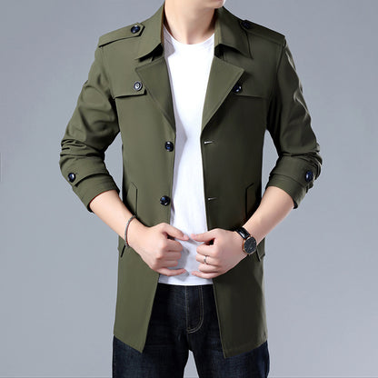 Green trench coat worn by a person on a gray background