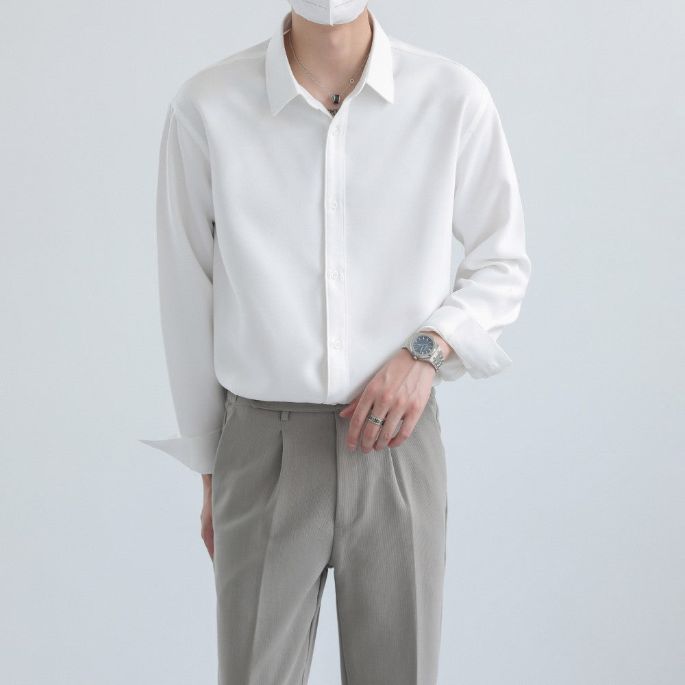 Person wearing a white shirt and gray pants on a light gray background