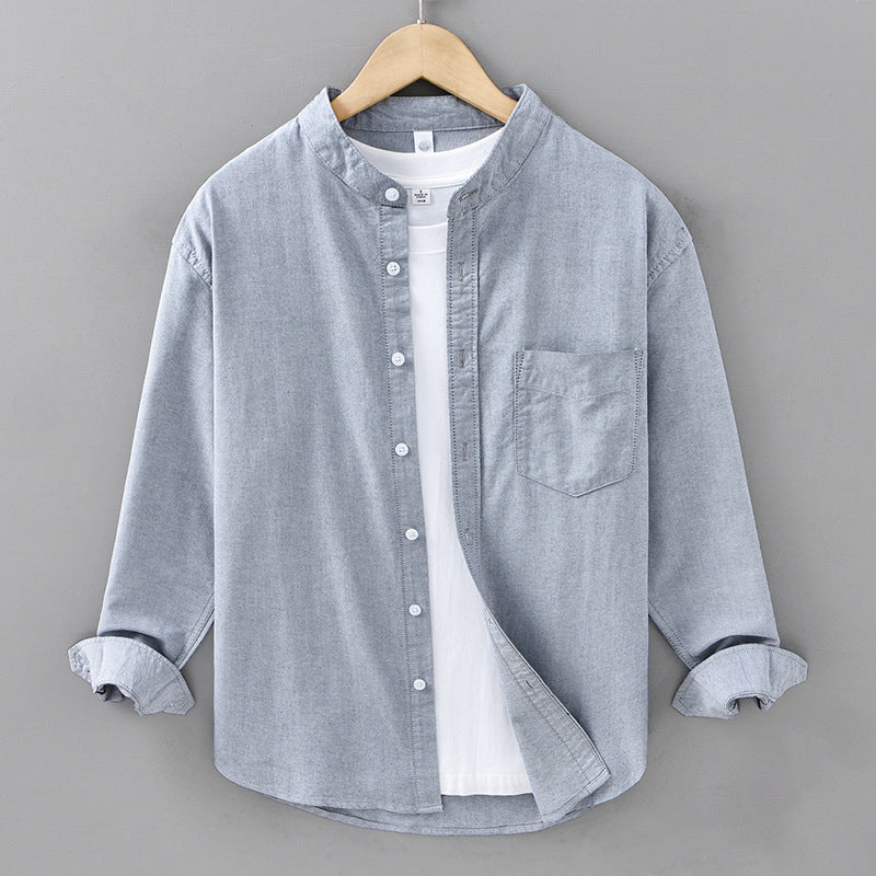 Gray button-up shirt on a hanger against a gray background