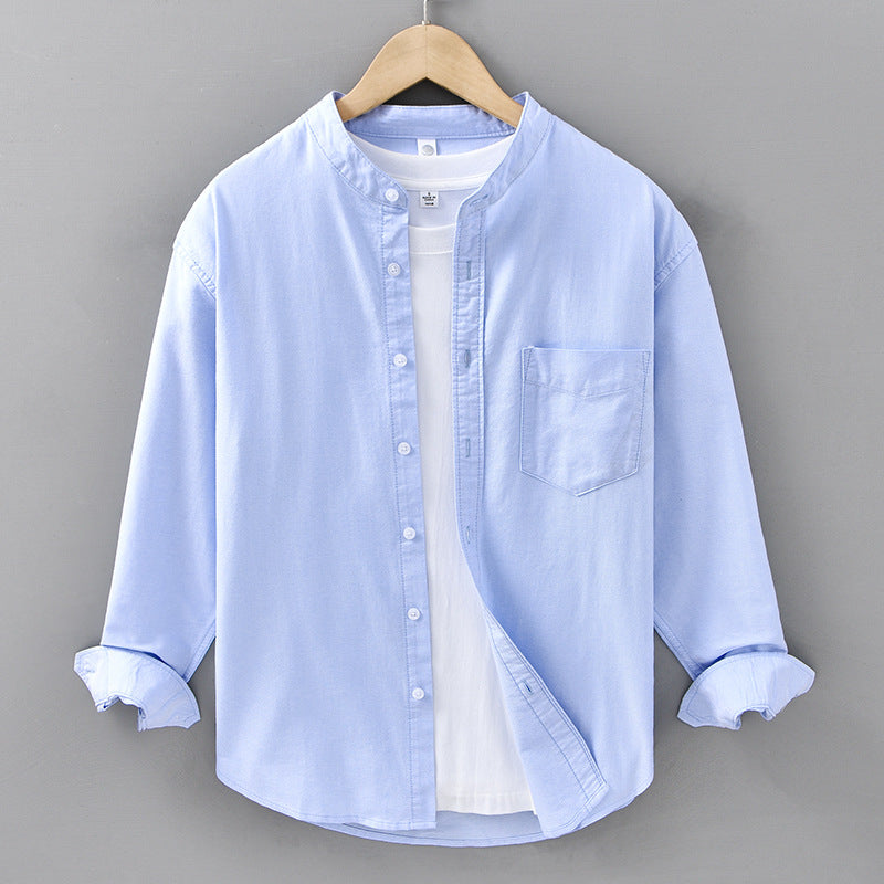 Light blue button-up shirt on a hanger against a gray background
