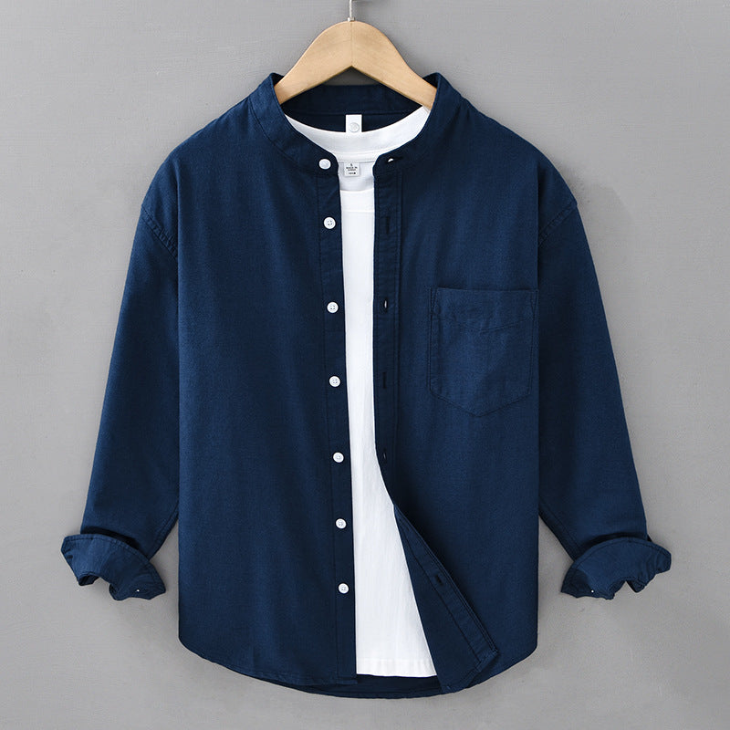 Navy blue shirt with white collar on a hanger against a gray background