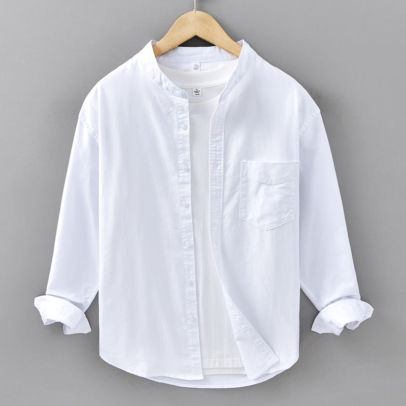 White shirt on a wooden hanger against a gray background