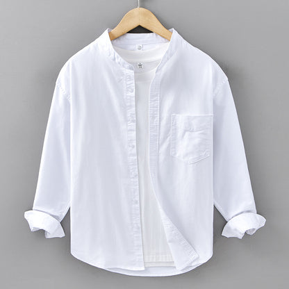 White shirt on a wooden hanger against a gray background